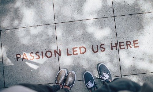 A tiled floor which reads "Passion Led us Here" - a message from the His and Her FI Post financial independence blog